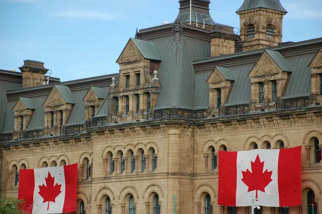 Drapeaux canadiens sur un édifice historique en pierre