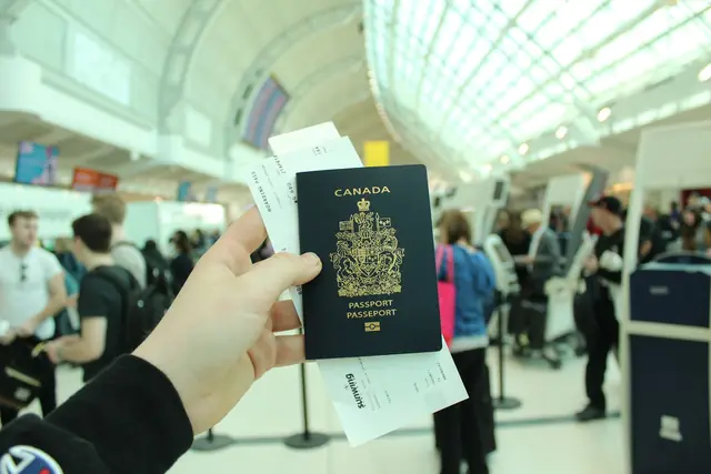 Canadian passport held up in an airport terminal