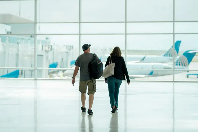 Two travellers walking through an airport terminal
