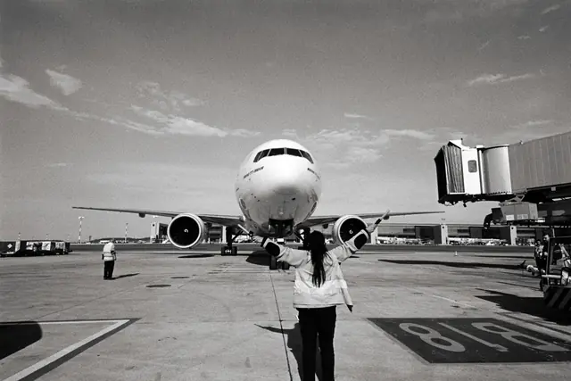 Traveller on an airport apron watching a passenger jet